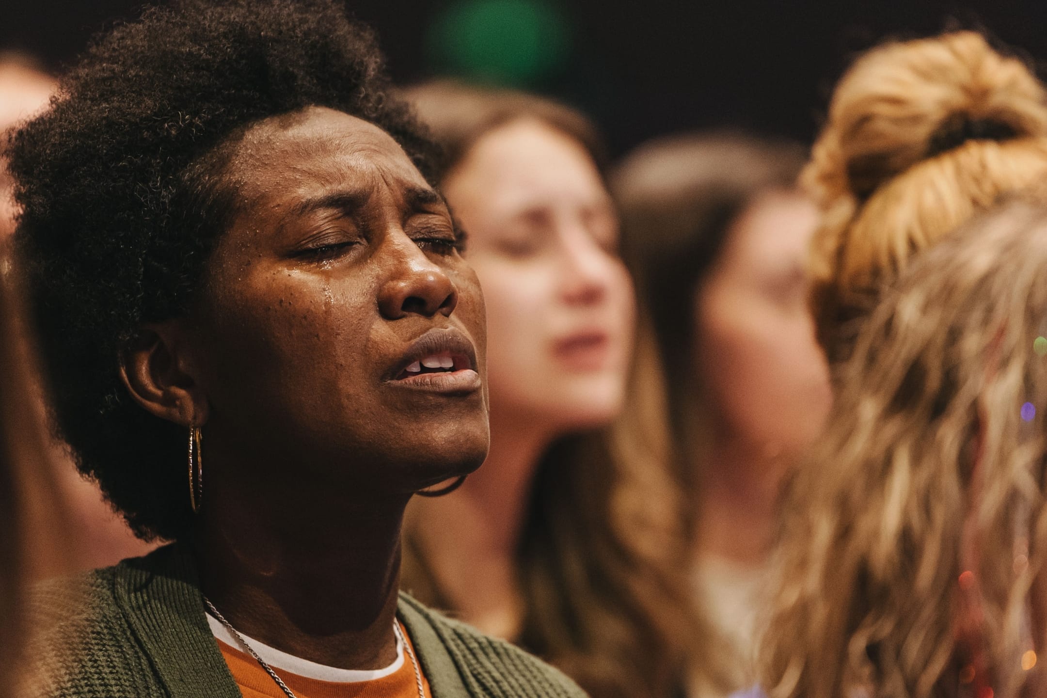 Woman praying with tears streaming down her face